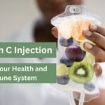 A medical professional holding an IV drip bag filled with fresh fruits like oranges, grapes, and kiwi, symbolizing the benefits of Vitamin C injection for health and immune system support. Skin Studio logo in the top left corner.